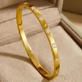 Detailed macro view of a luxury 18K gold-plated titanium steel bangle with clear zircon inlays. - Dotted Rhinestone Style (30-B-11)