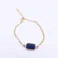 Detailaufnahme eines blauen Lapislazuli-Steins an einem verstellbaren goldenen Kettenarmband - 12x24mm / Lapislazuli