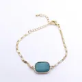Detailed view of gold chain bracelet featuring a turquoise square stone centerpiece - 12x24mm / Amazonite