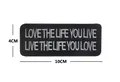 Detailweergave met 10x4cm afmetingen van de zwart geborduurde tekst morele patch - LOVE THE LIFE (V00915)