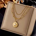 Détail d'un collier multicouche doré en acier inoxydable avec son pendentif soleil. - Style Double Rang avec Pendentif Rond Étoile Rayonnante (N1846)