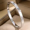 Elegant silver titanium steel bangle featuring diagonal crystal pavé in a tan box - Diagonal Stripe Rhinestone Style (35-D-1)