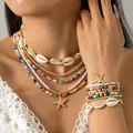 Primer plano de collar de cuentas bohemio y pulsera de conchas en modelo - Set de joyas