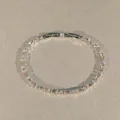Makro-Draufsicht eines eleganten Silberarmbands mit Baguette- und hellen Rundsteinen. - Champagnerfarbener Quadratischer Vollstrass-Stil / Silber