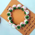 Dettaglio del braccialetto di Halloween con bulbi oculari insanguinati e iride verde - Occhi Verdi Malvagi