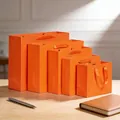 Sacchetti regalo di carta arancione brillante con manici in nastro in cinque misure - (Verticale) 12L*5.7P*16A / Arancione