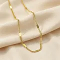 Elegante collar minimalista de acero de titanio dorado sobre una suave tela de seda beige - Cadena Plana (86498) / 1 Pieza (Embalaje Individual) / Dorado