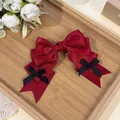 Detail of a sweet red satin bow hair clip with black mini bows in Lolita style. - Burgundy