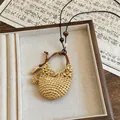 Detailed shot of resort-style woven pendant necklace with leather cord and pearl - Woven Round Bag Style (2 Necklace-Coffee)