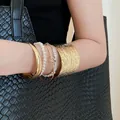 Retro gold-toned chunky bangles and a white pearl bracelet set worn on model's arm - Hammered Pearl Jewelry Set (52) / Five-Piece Set / Gold-White