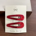 Paire de barrettes à cheveux en tissu pailleté rouge sur une carte Suanmu Design blanche - Éventail Rouge Martelė