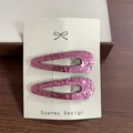 Paire de barrettes à paillettes violettes brillantes sur une carte de présentation - Rose Ajouré