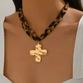 Detail van goudkleurige gehamerde kruishanger aan een dubbelstrengs luipaardprint ketting - Kruis Stijl (X1826C)
