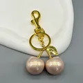 Detailansicht eines goldfarbenen Kirsch-Schlüsselanhängers mit rosa Perlenanhängern - Rosa