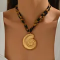 Detailweergave van een gouden schelphanger ketting met een hippe luipaardprint stoffen band - Schelp Stijl (X1826D)