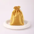 Elegant gold satin drawstring gift pouch for jewelry packaging and luxury items. - Gold