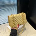 Elegant gold quilted shoulder bag with stylish chain strap and secure metal lock - Gold
