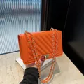 Chic orange chevron quilted crossbody bag with elegant gold-tone chain strap and lock - Orange