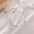 Elegante pulsera de acero de titanio plateado con cruz minimalista y una circonita - Pulsera Cruz Color Acero