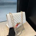 Elegant white quilted crossbody bag featuring a gold chain strap and stylish lock detail - White