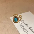 Detailed macro shot of a gold open ring with a turquoise stone and twisted rope border - Single Artificial Turquoise Style