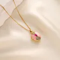 Primer plano de un collar relicario dorado con esmalte rosa y piedra roja central - Estilo Esmalte Rosa Gema Roja (t1518-j) / Dorado