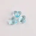 Detaillierte Makroansicht von drei transparenten hellblauen herzförmigen Acrylperlen - 8.8x10.3x5.9mm / Seeblau