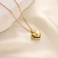 Detailed macro shot of a golden heart-shaped photo locket necklace on white silk fabric - Heart Starburst Pattern Style (t1520-j) / Gold