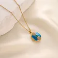Primer plano de un collar relicario de esmalte dorado con una piedra preciosa verde central. - Estilo Esmalte Azul Lago Gema Verde (t1517-j) / Dorado