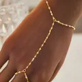 Dettaglio di un elegante bracciale a mano in catena dorata con anello da donna - Stile Catena Delicata Minimalista (116) / Oro