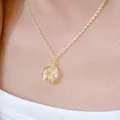 Macro view of a gold-plated necklace with a delicate white dried flower in a glass pendant. - Dried Flower Pendant + Necklace