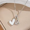 Primo piano della collana con doppio ciondolo a cuore e zirconi scintillanti - Collana a Cuore (6354) / Argento