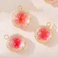 Dettaglio macro di un ciondolo tondo in vetro con all'interno un vero fiore essiccato - Ciondolo Fiore Secco Rosso