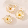 Dettaglio di ciondoli in vetro tondi con fiori bianchi secchi e cornice dorata - Ciondolo Fiore Secco Bianco