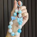 Close-up of a blue candy-colored beaded charm with a bow and heart detail - Blue