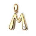 Detailed macro view of a gold-plated stainless steel letter M pendant with a crystal - Letter M