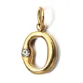 Close-up detail of golden letter O pendant with sparkling clear gemstone inlay - Letter O