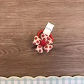 Primo piano di un elastico per capelli a fiore in tessuto a pois rossi su legno. - Rosso a pois