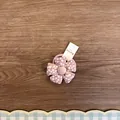 Dettaglio di un elastico per capelli a fiore in tessuto rosa per bambini su legno - Rosa Floreale