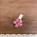 Nahaufnahme eines rosa floralen Stoffhaargummis für Mädchen mit süßem Blumendesign - Rosarot Floral