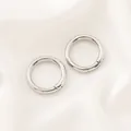 Gros plan de deux anneaux à ressort circulaires argentés pour la création de bijoux DIY. - Fermoir à Ressort Rond (20mm) / 1 Pièce / Or blanc