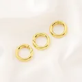 Détail de trois fermoirs à ressort circulaires plaqués or 14 carats sur fond de soie blanche - Fermoir à Ressort Rond (14mm) / 1 Pièce / Or 18K