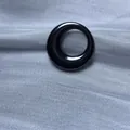 Vue macro d'une perle de bijoux DIY circulaire noire brillante sur tissu argenté - Cercle Lisse / 5 Pièces / Canon de fusil