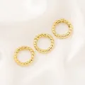 Gros plan sur trois fermoirs à ressort torsadés plaqués or 14K pour bijoux DIY. - Fermoir à Ressort Rond Torsadé (18mm) / 1 Pièce / Or 18K