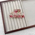 Primo piano di un fermaglio per capelli vintage con motivi di rose rosa. - Stile Medio / Fiore Rosa