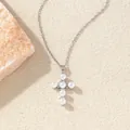 Elegante silberne Kreuzhalskette mit Perlen und Zirkonia auf warmem strukturiertem Grund. - C00159 / 18K-Gold