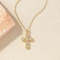 Eleganter goldfarbener Zirkonia-Kreuzanhänger an einer Halskette auf strukturiertem Grund - C00179 / 18K-Gold