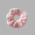 Détail rapproché d'un chouchou en peluche rose doux avec une texture duveteuse pour l'hiver. - Rose