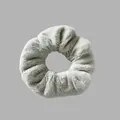 Détail macro d'un chouchou en peluche gris doux montrant la texture élégante et floue - Vert clair