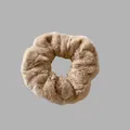 Vue détaillée montrant la texture douce en fausse fourrure d'un chouchou en peluche brun. - Chameau